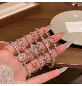 Close-up of elegant silver-colored zircon bracelets with heart and bow designs.