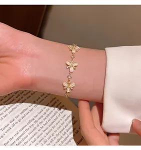 Close-up of elegant gold butterfly bracelet with cat-eye stones and sparkling zircons