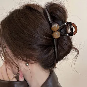 Elegant large brown resin shark hair claw clip for thick hair bun styling and updos