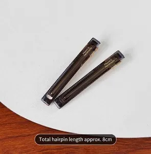 Close-up detail of dark translucent duckbill hair clips with length measurement.