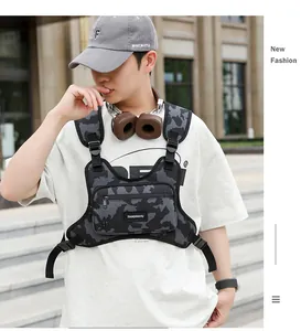 Modell trägt eine graue Camouflage-Taktik-Brusttasche in einer urbanen Umgebung.