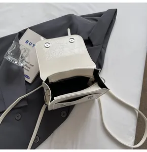 Interior view of off-white textured backpack showing magnetic snaps and zip pocket