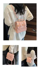 Detailed view of pink mini backpack with bow accents and top handle for commuting