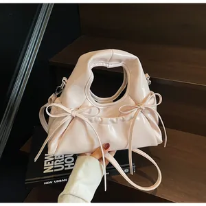 Detalle de un bolso rosa brillante con elegantes lazos y un asa resistente chic.