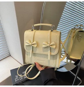 Trendy yellow mini backpack for women featuring bow details and crinkled leather texture.
