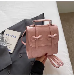 Close-up of stylish pink bow backpack showing wrinkled leather texture and top handle detail