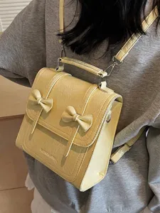 Fashionable yellow bow backpack for women featuring stylish crinkle leather finish