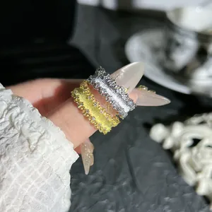 Dettaglio degli anelli vintage in oro e argento con una raffinata trama spazzolata.
