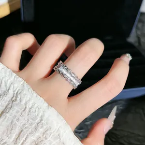 Primo piano di un anello vintage in argento spazzolato con pizzo e diamanti fini.