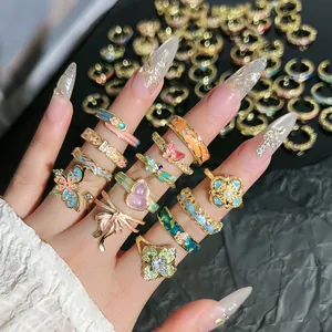 Primer plano de anillos vintage de esmalte de colores con diseños de flores y mariposas