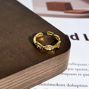 Nahaufnahme eines goldenen Vintage-Ringes mit Aststruktur und lila Edelsteinen