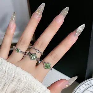 Nahaufnahme von mintgrünen Kristall Kleeblatt Ringen auf Modelfingern