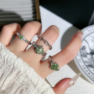 Detaillierte Nahaufnahme von eleganten minzgrünen Klee- und Rankenringen auf einer Modellhand.