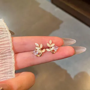 Close-up of elegant leaf-shaped stud earrings with sparkling square zirconia stones