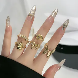 Nahaufnahme eines goldenen Vintage-Ring-Sets mit Schmetterlings-, Schleifen- und Blumendesign