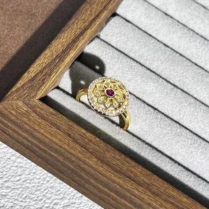 Detaillierte Makroansicht eines goldenen Vintage-Blumenrings mit rotem Edelstein