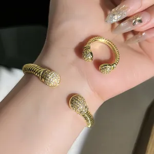 Elegante set di bracciale rigido e anello intrecciati in oro con sfere micro pave