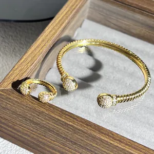Dettaglio del set bracciale e anello in oro a corda intrecciata con sfere di cristalli