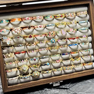 Filas de anillos de esmalte vintage de colores con diseños de flores y mariposas