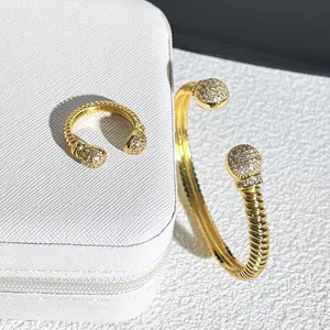 Primo piano di set anello e bracciale a cavo dorato con punte a sfera in cristallo