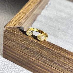Dettaglio ravvicinato di un anello aperto a treccia d'oro con sfere di cristallo