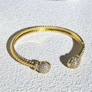 Dettaglio di un lussuoso bracciale a cavo intrecciato oro con sfere terminali micro-pavé
