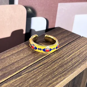 Detalle de anillo vintage esmaltado con patrones de estilo palaciego sobre madera