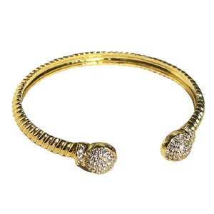 Dettaglio del bracciale rigido dorato a treccia con sfere di strass pavé vintage