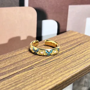 Anillo abierto vintage en oro con motivos florales en esmalte colorido y estilo corte.