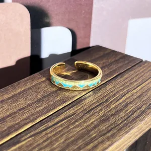 Vista macro detallada de un anillo ajustable de esmalte dorado vintage con montañas