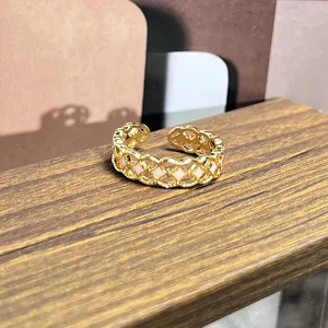 Detalle de un anillo dorado vintage con elegantes inserciones de esmalte blanco pulido
