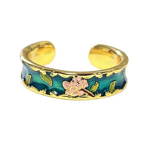 Primer plano de un anillo esmaltado vintage con motivos florales y borde dorado