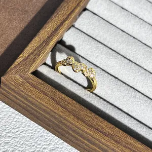 Detailansicht eines goldfarbenen Herzrings mit Pavé-Steinen in einer Schmuckschale