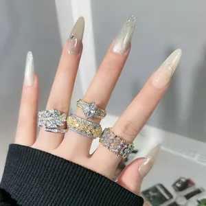 Detalle de cuatro anillos abiertos vintage estilo palacio con diamantes en dedos cuidados