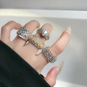 Primer plano de cuatro anillos de estilo corte vintage con pavé de diamantes y acabado bicolor.