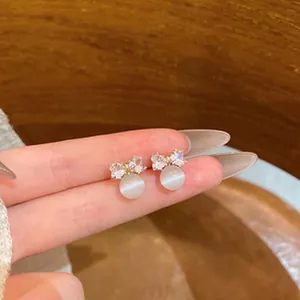 Macro view of elegant bow stud earrings with micro-set zircons and cat's eye stones