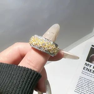 Primer plano de un anillo ancho bicolor vintage incrustado con cristales brillantes.