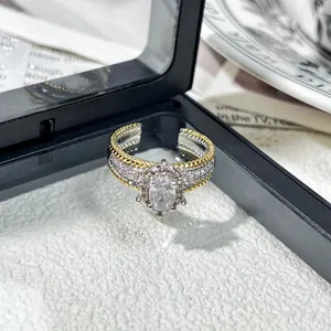 Primer plano de anillo vintage bicolor con halo de cristal ovalado y micro-pavé