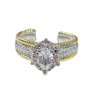 Primer plano de un anillo abierto bicolor vintage con diamantes pavé y piedra ovalada