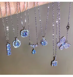 Detail view of various zircon titanium steel necklaces with sparkling light blue pendants