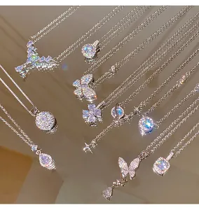 Collection of sparkling zircon pendants on silver chains displayed on a mirror