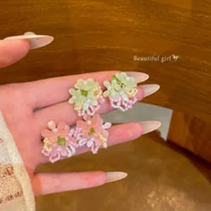 Detailed view of pink and green mesh flower earrings with bead accents