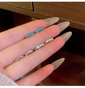 Detailed macro shot of elegant zircon small hoop earrings in blue, white, and pink.