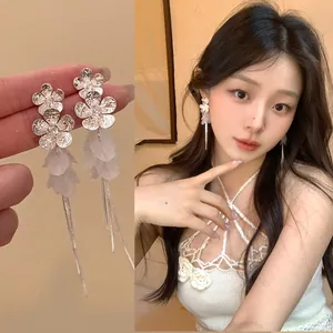 Elegant silver flower shell tassel earrings shown on an Asian model and product close-up