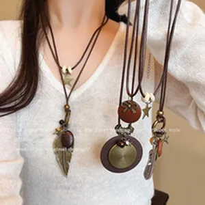 Detailed view of vintage ethnic long necklaces with feather and ornate metal pendants