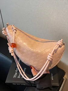 Elegante bolso de hombro de media luna en cuero trenzado rosa con cuenta de ámbar