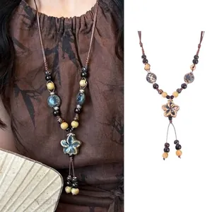 Detail view of ethnic long necklace with ceramic flower pendant and vintage beads
