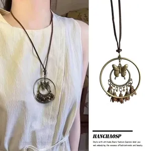 Detail view of retro Zen style long butterfly feather necklace with Bohemian pendant