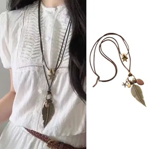Detail of a retro bohemian feather necklace with ceramic beads on a long cord strap