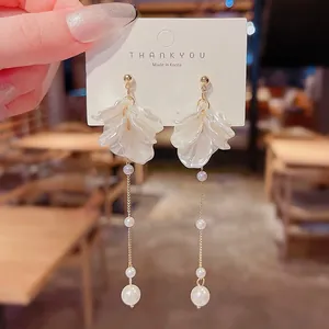 Detailed view of elegant white petal tassel earrings with delicate white pearls
